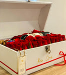 Baul Mediano con 50 rosas con botella de vino tinto y macarrones